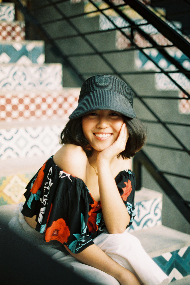 Young Woman in Black Cap and Off Shoulder Printed Blouse